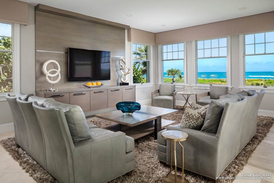 The custom wall unit in a metallic grey finish is placed adjacent to the vast ocean views beyond. It offers contrast to the rift-cut oak and iron cocktail table and grey leather sofas to create layers of luxury. The entire estate is wired as a smart home.