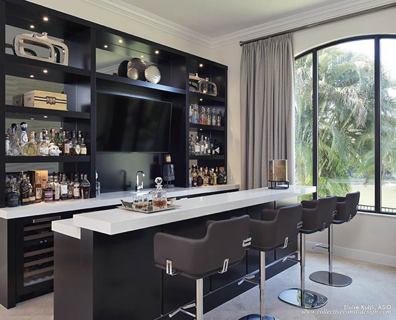 This custom bar was installed in what was previously the living room, adjacent to the new fireplace and dining room. Using grey mirror, a big-screen television, Sub-Zero appliances, and white quartz slab tops, it offers a superb place to entertain.