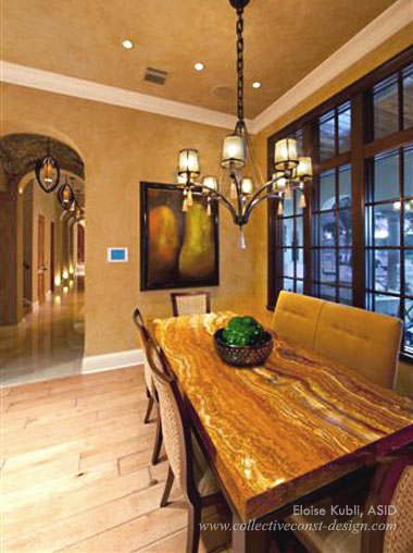 In the breakfast area, swirls of incredible color show off the veins in the beautiful, red-onyx top and leather-wrapped wood table, while the woven sea grass chairs add texture. Asian inspired, the chandelier speaks volumes with its forged iron base and hanging shade pendants made of recycled glass.