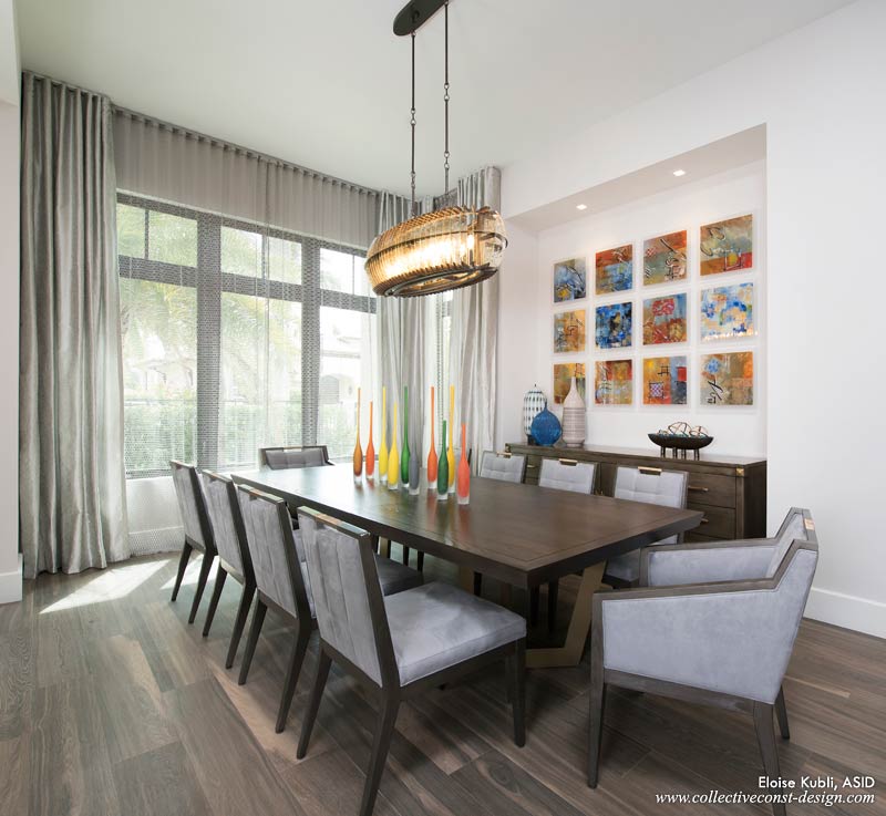 A stunning, oval-shaped chandelier with a bronze-and-gold frame and antiqued mirrored panels casts a romantic glow.