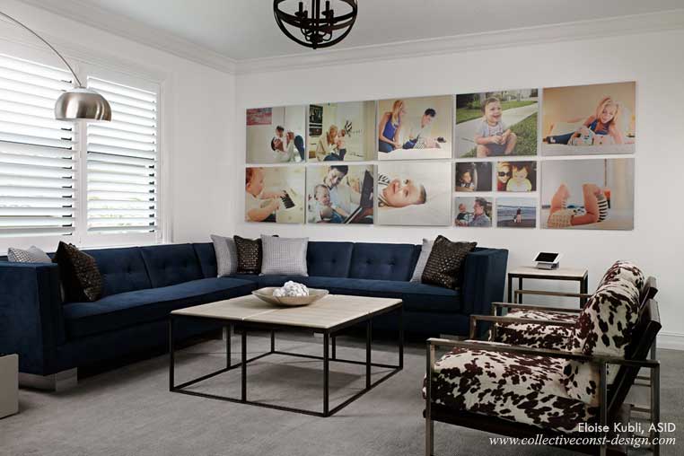 A large custom sofa with silver metallic block legs anchors a wall of family photos.