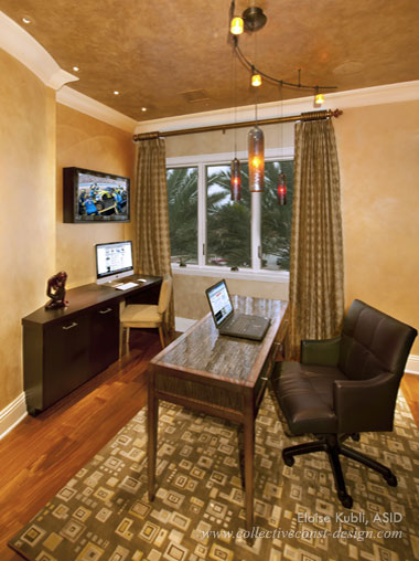 When more than one family member will use the home office, it can be a good idea to have more than one desk. Overhead lighting illuminates both work spaces, and a TV screen hangs over the computer desk in the corner.