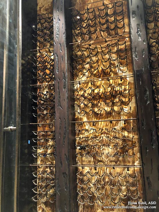 Detail of wine racks, rough-hewn wood framing, and glass doors.